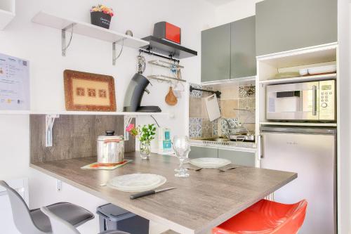 une cuisine avec un comptoir, une table et des chaises dans l'établissement À 190m de la plage - Studio 2 personnes, à Bénodet