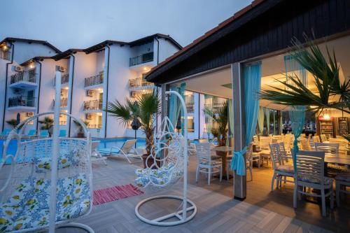 a patio with chairs and tables on a building at Royal Calisto Hotel in Sozopol