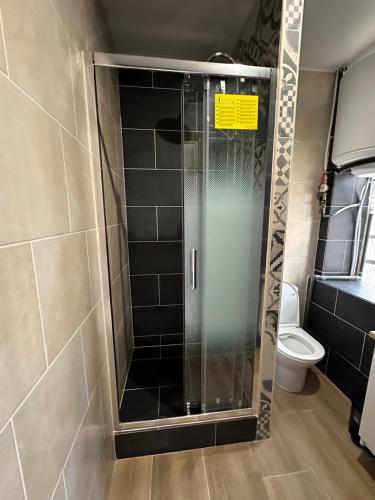 une douche avec une porte vitrée dans une salle de bain dans l'établissement HL Home Paris Ivry, à Ivry-sur-Seine