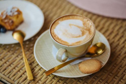 a cup of coffee on a plate on a table at Apartment Hotel Pfeifer in Gaschurn