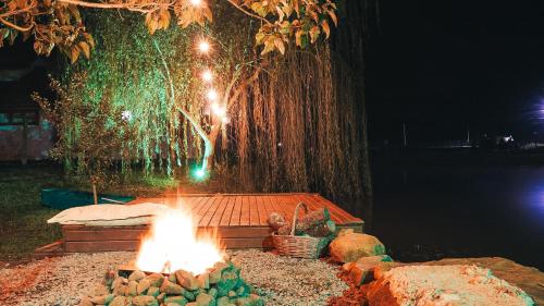 a fire pit in front of a tree at night at Sand River - Cabanas com românticas hidromassagem entre Urubici e Urupema in Rio Rufino