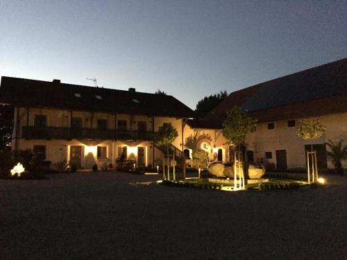 a couple of buildings at night with lights at Gut Schwarz-n Hof Ferienwohnungen in Bad Griesbach