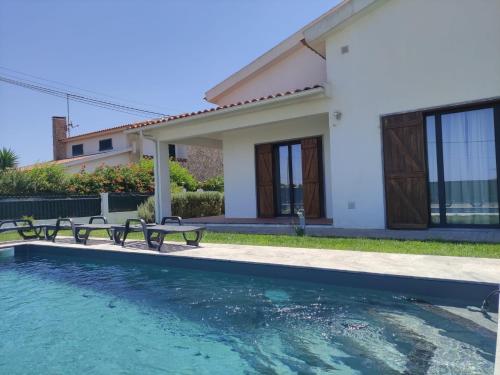 eine Villa mit Swimmingpool und ein Haus in der Unterkunft Casa Branca in Ericeira