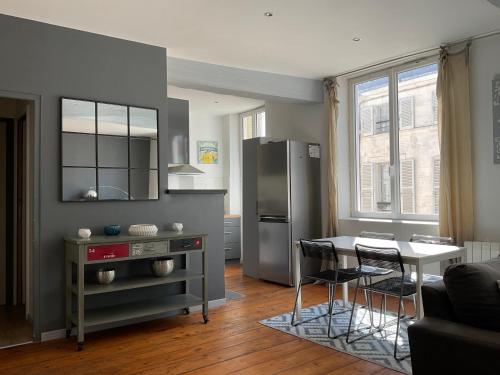 Il comprend une cuisine équipée d'un réfrigérateur, d'une table et de chaises. dans l'établissement Très bel appartement 55 m2, à La Rochelle