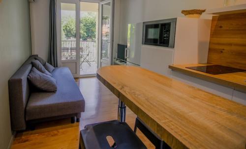 une cuisine avec une table, un canapé et un four micro-ondes dans l'établissement La maison des roses 1 Avignon, à Villeneuve-lès-Avignon