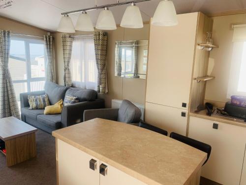 a kitchen and living room with a couch and a table at Rockley Park Haven in Lytchett Minster
