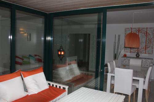 a glass room with a couch and a table at Apartment Outeiro da Vela in Cascais