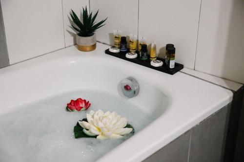 een badkuip met een bloem in het water bij La Martina Glam Residence - 15 Airport Macedonia in Trílofon
