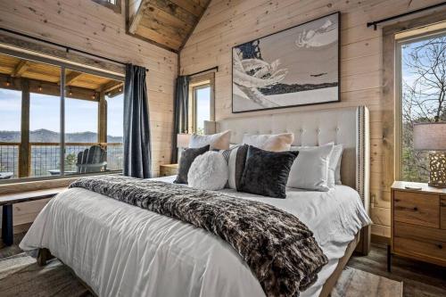 Un dormitorio con una cama grande en una habitación con ventanas. en Luxury Endless View 3 King Suites Billards Pool, en Sevierville