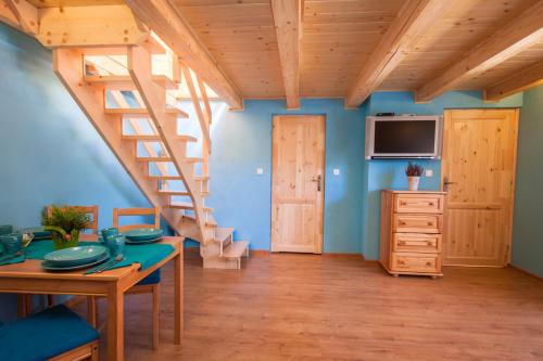 a living room with a wooden staircase and a table at Alpejska Wioska in Istebna