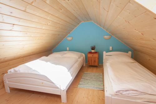 two beds in a room with a wooden ceiling at Alpejska Wioska in Istebna