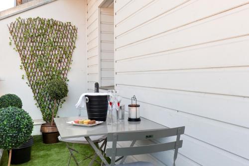 une table sur la terrasse arrière avec une plante dans l'établissement Chambre VENUS avec Jacuzzi privatif, à Vichy