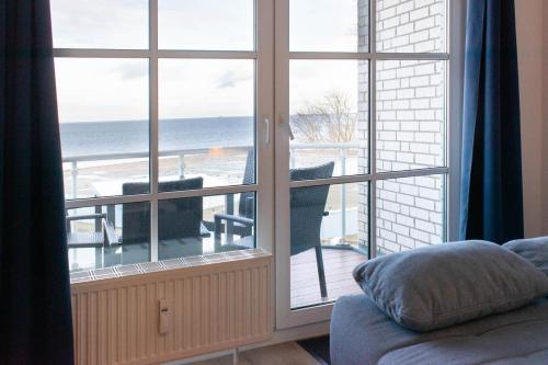 um quarto com uma grande janela com vista para o oceano em Ferienwohnung MehrBlick 33 em Niendorf