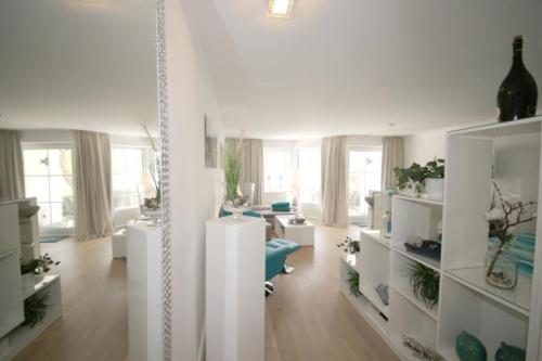 salon z białymi ścianami i białymi meblami w obiekcie Ferienwohnung Strandallee 200 w mieście Timmendorfer Strand