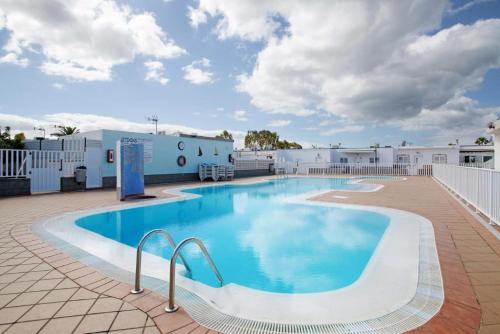 a large swimming pool on a patio next to a building at Bungalow Vista Dunas 32 in San Bartolomé de Tirajana