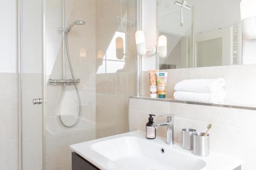 a white bathroom with a shower and a sink at Ferienwohnung Strandnah in Timmendorfer Strand