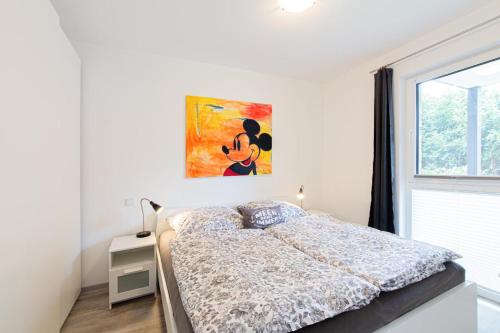 a bedroom with a bed and a painting on the wall at Ferienwohnung Stern 3 Scharbeutz in Scharbeutz