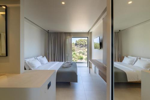 a hotel room with two beds and a window at PHEIA, Vriniotis Resorts in Katakolon