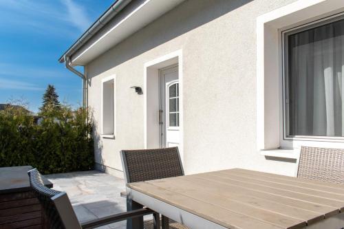 a patio with a table and chairs on a balcony at Ferienwohnung 3 Haus Meeresrauschen - Bungalow in Haffkrug
