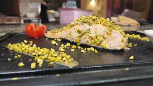 a piece of meat on a pan with corn and tomatoes at Hotel terme di orte in Orte