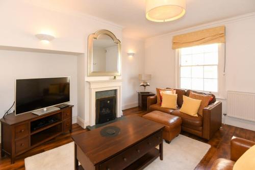 a living room with a couch and a television at Spacious Townhouse Private Parking Central Wells in Wells