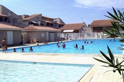 un groupe de personnes nageant dans une piscine dans l'établissement Appartement du port, à Saint-Cyprien