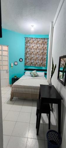 a bedroom with a bed and a blue wall at Hotel Casa Luna in Palenque