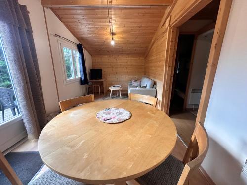 une salle à manger avec une table et des chaises en bois dans l'établissement Chalet 45m2, à Mios