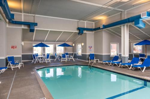 a swimming pool with blue chairs and tables at Park Point Marina Inn in Duluth