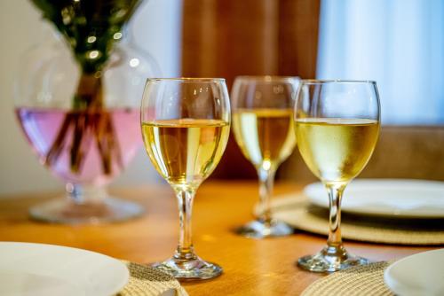 three glasses of white wine sitting on a table at Apartments Częstochowa - Słoneczna Kamienica - Parking free! in Częstochowa