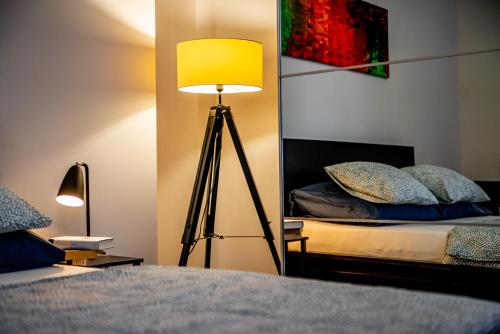 a bedroom with a lamp next to a bed at Apartments Częstochowa - Słoneczna Kamienica - Centrum - Prywatny Parking free! - Klimatyzacja ! in Częstochowa