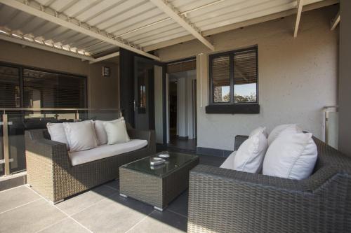 a patio with two wicker chairs and a table at Villa Moyal in Johannesburg