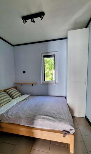 a bedroom with a large bed and a window at Black&White in Mrągowo