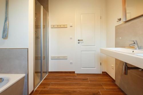 a bathroom with a sink and a shower at Ferienhaus NORTH COAST in Scharbeutz