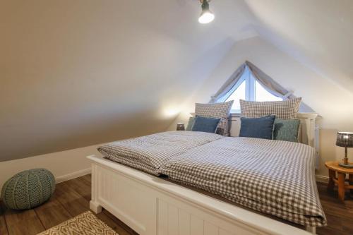 a bedroom with a bed with blue pillows and a window at Ferienhaus NORTH COAST in Scharbeutz