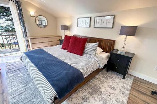 Searose BeachにあるOcean Front, Agate at Oregon House, Stairs to the Beach!のベッドルーム1室(大型ベッド1台、赤い枕付)