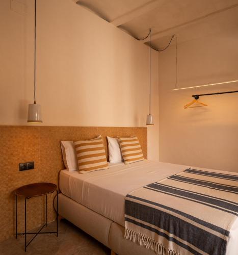 a bedroom with a bed with striped sheets and pillows at VICTORIA - by Ático73 in Medina Sidonia
