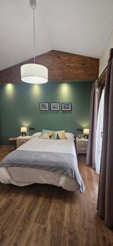 een slaapkamer met een groot bed en een groene muur bij Casa Elisa - Albergue turístico superior in San Pedro de Latarce