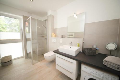 a white bathroom with a sink and a toilet at Ferienwohnung Küstentraum 2 in Travemünde