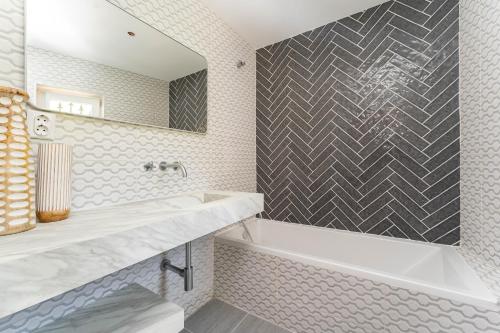 a bathroom with a tub and a sink and a mirror at Luxury Casa Madeira, HEATED Salt Water Pool and Panoramic Woodfire Sauna in Lagos