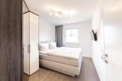 沙博伊茨Ferienwohnung Kleine Auszeit的一间白色的小卧室,配有床和窗户