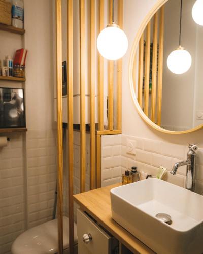 une salle de bain avec un lavabo et un miroir dans l'établissement Appartement Studio Paris La Défense, à Suresnes