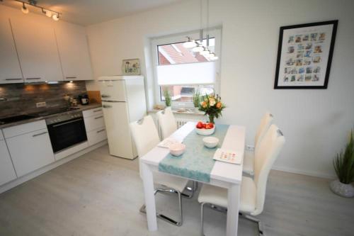 a kitchen with a white table and white appliances at Ferienwohnung Meeresstrand in Haffkrug