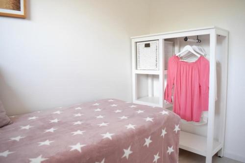 a bedroom with a bed and a shelf with a pink shirt at Ferienwohnung Meeresstrand in Haffkrug