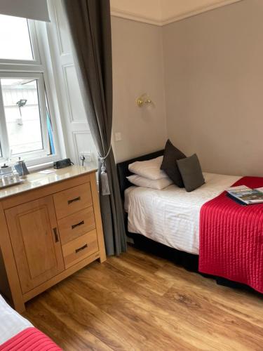 a bedroom with a bed and a sink and a window at Daviot Guest House in Ayr