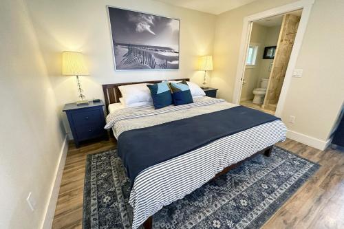 a bedroom with a large bed with blue pillows at Ocean Front, Cottage at Oregon House, Stairs to the Beach! in Searose Beach
