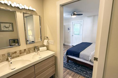 a bathroom with a bed and two sinks and a mirror at Ocean Front, Cottage at Oregon House, Stairs to the Beach! in Searose Beach