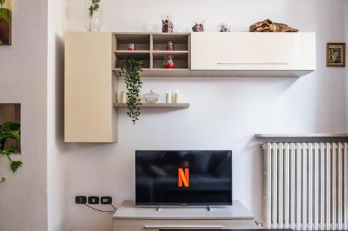 a living room with a flat screen tv on a tv stand at Residence Molinetto in Ravenna