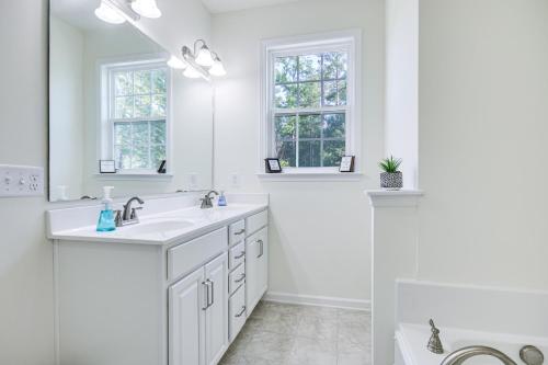 a white bathroom with two sinks and two windows at Savannah Lakes Village Home Golf and Hike! in McCormick