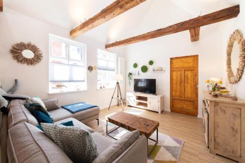 un salon avec un canapé et une table dans l'établissement Ferienwohnung Nordic Nature Loft in Travemünde direkt in der Vorderreihe inkl Privatsauna, à Travemünde